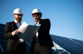 Engineers examining blueprint in solar panel farm - PhotoDune Item for Sale