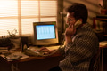 Caucasian Man Using Landline Phone While Working on Computer - PhotoDune Item for Sale
