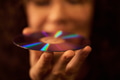 Caucasian Young Adult Woman Holding Compact Disc with Reflected Light - PhotoDune Item for Sale