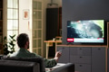 Man Relaxing on Sofa While Streaming News Broadcast - PhotoDune Item for Sale