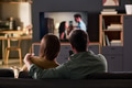 Young Couple Relaxing on Sofa Watching Television Together at Home - PhotoDune Item for Sale