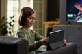 Child Girl Using Digital Tablet While Sitting on Sofa Indoors - PhotoDune Item for Sale