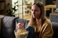 Young Adult Woman Watching Television While Eating Popcorn Indoors - PhotoDune Item for Sale