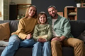 Portrait of Family Sitting Together Smiling and Relaxing on Living Room Sofa - PhotoDune Item for Sale