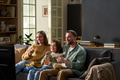 Young Adult Parents and Child Watching Movie and Eating Popcorn Together - PhotoDune Item for Sale