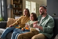 Young Adult Couple and Child Watching Television and Eating Snacks - PhotoDune Item for Sale