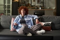 Young Adult Woman Smiling While Watching Television at Home - PhotoDune Item for Sale