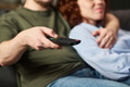 Young Man Holding Remote Control While Embracing Young Woman - PhotoDune Item for Sale