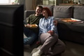 Young Couple Sitting on Floor Eating Pizza and Watching Television - PhotoDune Item for Sale