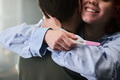 Young Woman Hugging Man While Showing Positive Pregnancy Test - PhotoDune Item for Sale