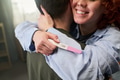 Young Woman Hugging Man While Holding Positive Pregnancy Test - PhotoDune Item for Sale