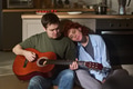 Young Man Playing Guitar While Young Woman Leaning on Shoulder - PhotoDune Item for Sale