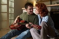 Young Man Playing Guitar While Sitting with Young Woman - PhotoDune Item for Sale