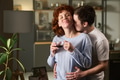 Young Man Hugging Young Woman Drinking Coffee Indoors - PhotoDune Item for Sale