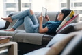 Young Woman Reading Ebook With Ereader On Couch - PhotoDune Item for Sale