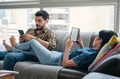 Couple Reading Ebook With Ereader On Couch - PhotoDune Item for Sale