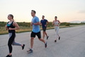 A diverse group of runners trains together at sunset. - PhotoDune Item for Sale