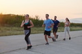 A diverse group of runners trains together at sunset. - PhotoDune Item for Sale