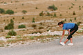 Determined Female Athlete Stretching After an Intense Run Through Rugged Mountain Terrain. - PhotoDune Item for Sale