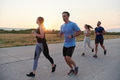 A diverse group of runners trains together at sunset. - PhotoDune Item for Sale