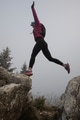 silhouette of a fitness woman trail runner jumping over a cliff and running to a rocky mountain top - PhotoDune Item for Sale