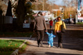 A loving couple strolls through a sunlit park with their young son, surrounded by the vibrant colors - PhotoDune Item for Sale