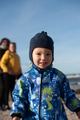 A happy family strolls along a chilly autumn beach, with their young son joyfully running ahead - PhotoDune Item for Sale