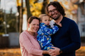 On a sunny autumn day in the park, a mother and father lovingly embrace their young son, sharing - PhotoDune Item for Sale
