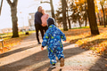 A joyful little boy in his winter coat and hat plays happily in the park, surrounded by the love and - PhotoDune Item for Sale