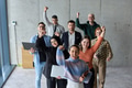 A diverse team of business professionals ecstatically celebrating their success in a modern office - PhotoDune Item for Sale