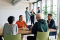 A diverse team of business professionals engaged in a discussion around a conference table in an - PhotoDune Item for Sale