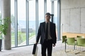 A determined businessman in a black suit confidently walks through the office, embodying - PhotoDune Item for Sale