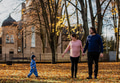 A loving couple strolls through a sunlit park with their young son, surrounded by the vibrant colors - PhotoDune Item for Sale