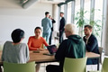 A diverse team of business professionals engaged in a discussion around a conference table in an - PhotoDune Item for Sale
