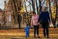 A loving couple strolls through a sunlit park with their young son, surrounded by the vibrant colors - PhotoDune Item for Sale