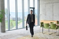 A determined businessman in a black suit confidently walks through the office, embodying - PhotoDune Item for Sale