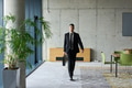 A determined businessman in a black suit confidently walks through the office, embodying - PhotoDune Item for Sale