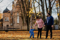 A loving couple strolls through a sunlit park with their young son, surrounded by the vibrant colors - PhotoDune Item for Sale