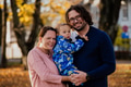 On a sunny autumn day in the park, a mother and father lovingly embrace their young son, sharing - PhotoDune Item for Sale