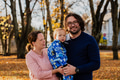 On a sunny autumn day in the park, a mother and father lovingly embrace their young son, sharing - PhotoDune Item for Sale