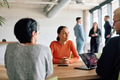 A diverse team of business professionals engaged in a discussion around a conference table in an - PhotoDune Item for Sale