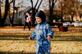 A joyful little boy in his winter coat and hat plays happily in the park, surrounded by the love and - PhotoDune Item for Sale