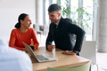 A young, diverse business team sitting together in a modern office, exchanging ideas and business - PhotoDune Item for Sale