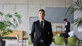 A close up portrait of a company director in a black suit, standing confidently in a modern office - PhotoDune Item for Sale