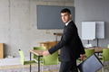 A determined businessman in a black suit confidently walks through the office, embodying - PhotoDune Item for Sale