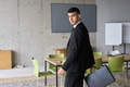A determined businessman in a black suit confidently walks through the office, embodying - PhotoDune Item for Sale