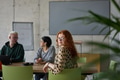A young, diverse business team sitting together in a modern office, exchanging ideas and business - PhotoDune Item for Sale