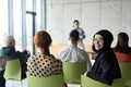 A diverse group of business professionals sits attentively in a modern office, actively - PhotoDune Item for Sale