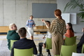 A diverse group of business professionals sits attentively in a modern office, actively - PhotoDune Item for Sale