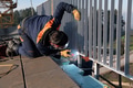 Industrial welder skillfully crafts a metal fence for a new business complex, using modern equipment - PhotoDune Item for Sale